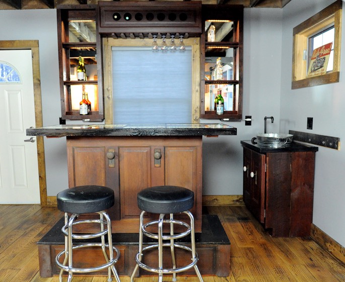 Home bar built out of circa 1930 recycled doors and old license plates for bar top