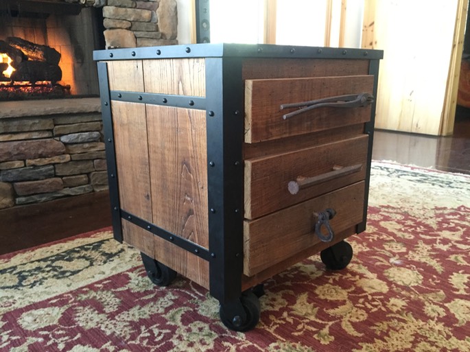 Industrial end table made from wormy chestnut wood (reclaimed from house built in early 1900's).   Custom made steel structure with welded old style rivets, then powder coated.  Three drawers with old tools attached for handles. Integrated outlet with usb charging port.